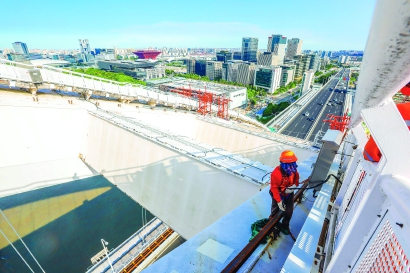 炎热的施工现场,每天都有20余位工人在高空加紧作业.